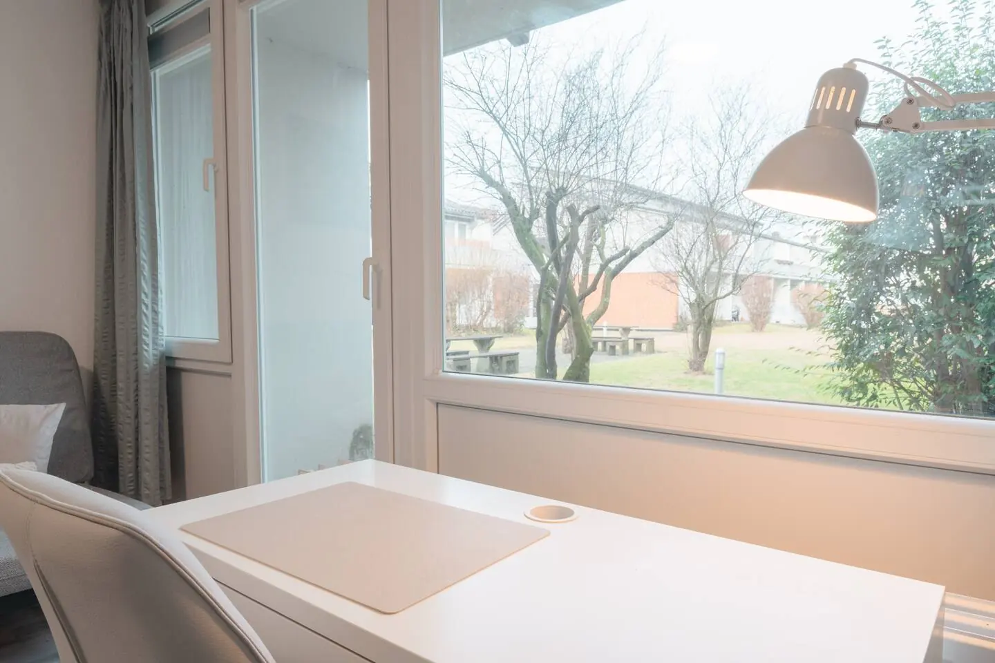 Arbeitsplatz mit Schreibtischlampe am Fenster