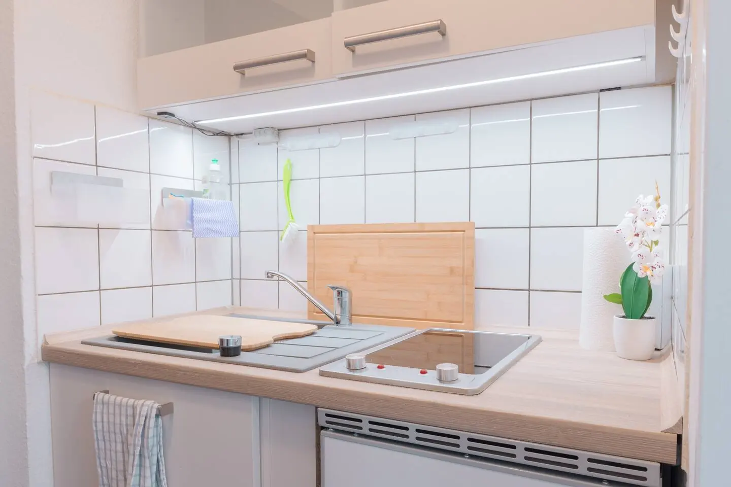 Kochnische mit Ceranfeld, Spüle und Kühlschrank